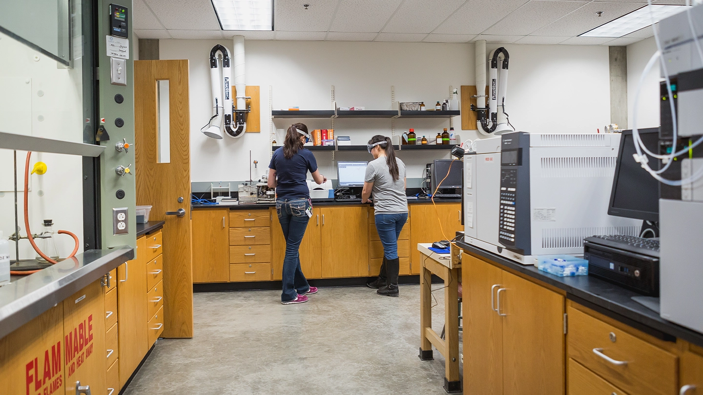 Two Biological Sciences master's degree students working in a lab.