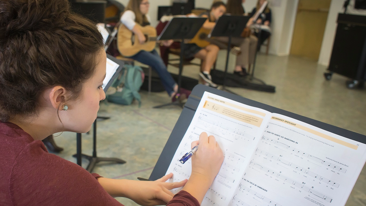Music education student reading sheet music.