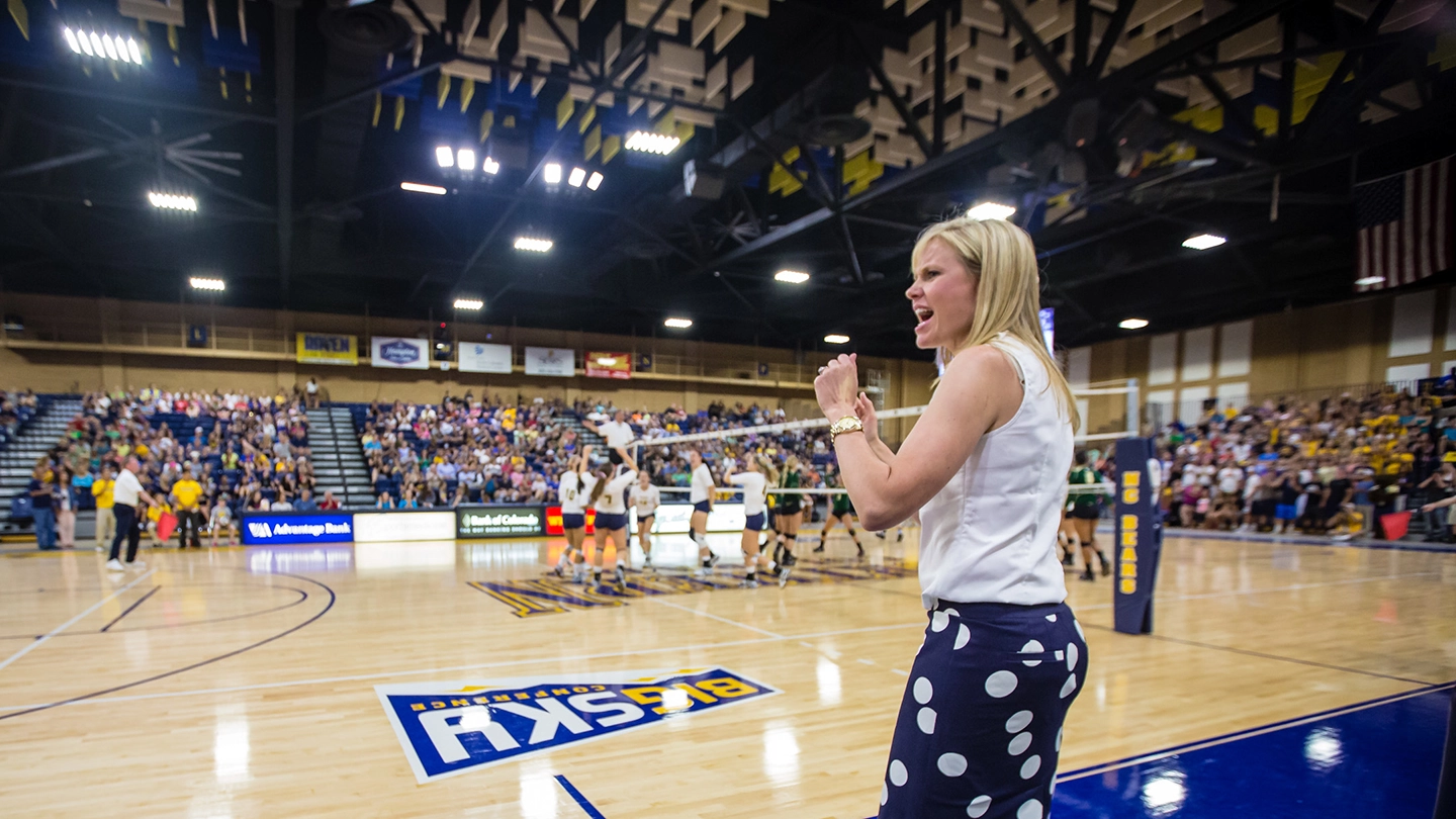 UNC Volleyball coach Lyndsey Oates coaching during a match.