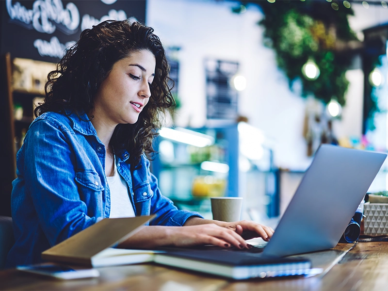 Communication Studies bachelor's degree completion student doing coursework online on her laptop.