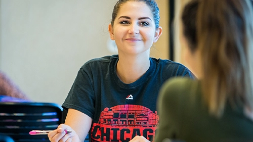 UNC student smiling during a group discussion.