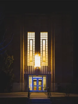 Nighttime lighted exterior view of main entrance of Carter Hall on UNC Campus.