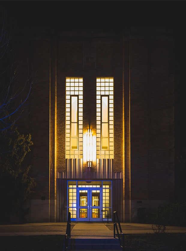 Nighttime lighted exterior view of main entrance of Carter Hall on UNC Campus.