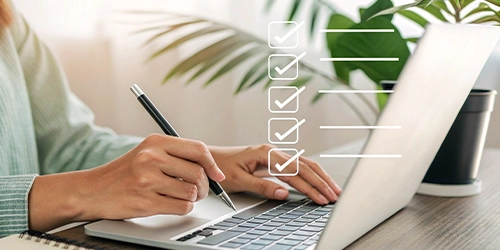 Close up of hands using a laptop with a visual of form checkboxes floating in the image.