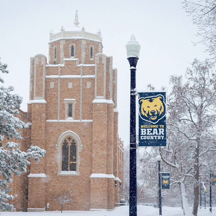 Gunter Hall and a Bear Country sign on a snowy day.