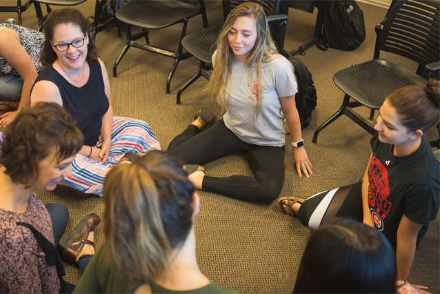 Photo of UNC students and faculty sitting in a circle talking