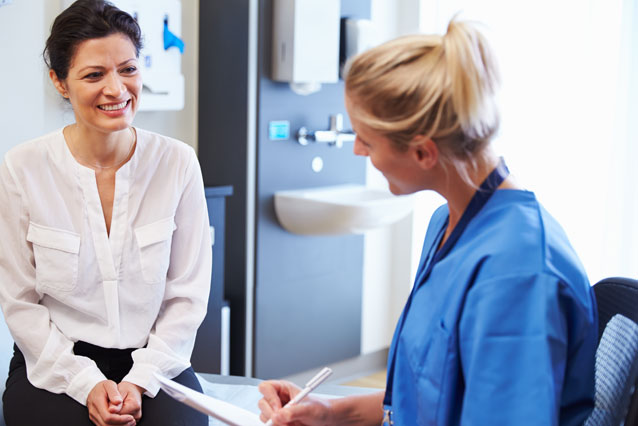 Photo of FNP nurse visiting with a patient